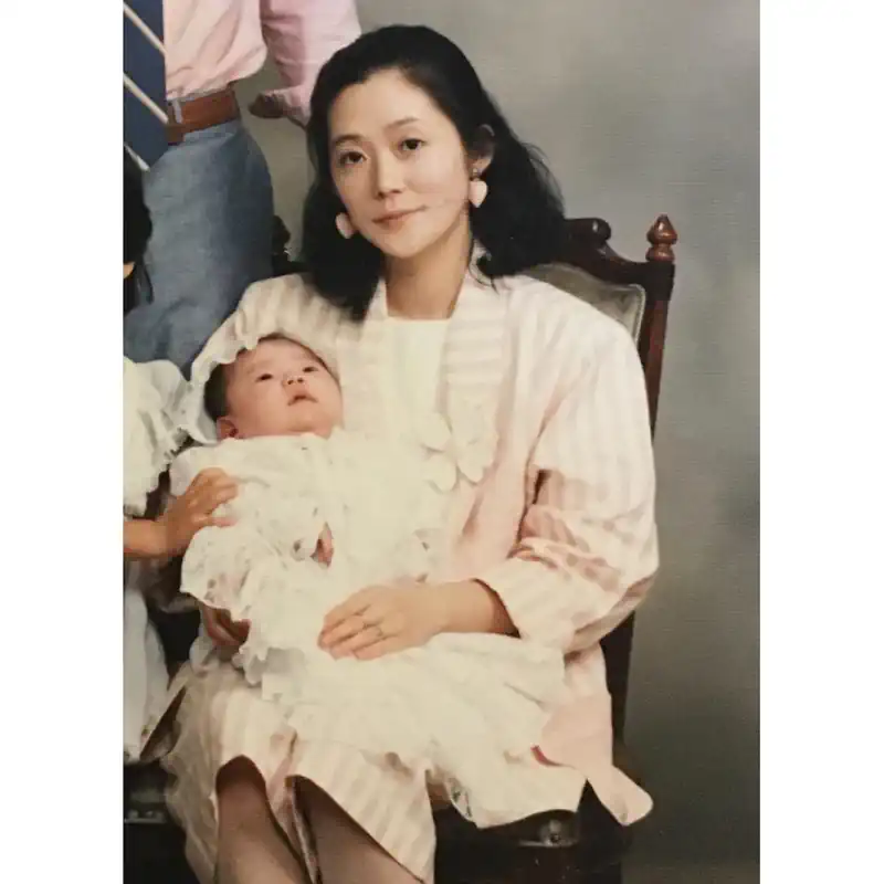 Childhood photo of Tao Okamoto with her mother holding her in her hands